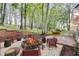 Outdoor stone fireplace with backyard seating, mature trees and backyard landscape at 2055 Timberland Dr, Cumming, GA 30040