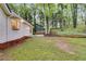 View of the backyard with trees, grass, and a small patio area off the back of the home at 2055 Timberland Dr, Cumming, GA 30040