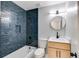Stylish bathroom featuring modern vanity, round mirror, and sleek, blue tiled shower at 2055 Timberland Dr, Cumming, GA 30040