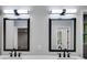 Bright bathroom featuring a double vanity with black fixtures and mirrors at 2055 Timberland Dr, Cumming, GA 30040