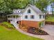 Charming two-story home with a brick foundation, landscaped yard, and inviting front porch nestled among lush greenery at 2055 Timberland Dr, Cumming, GA 30040