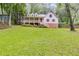Charming two-story home with a welcoming front porch and lush green lawn surrounded by mature trees at 2055 Timberland Dr, Cumming, GA 30040
