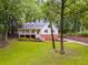 Charming home with welcoming front porch and lush green lawn surrounded by trees at 2055 Timberland Dr, Cumming, GA 30040