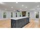 Kitchen island with seating, wine cooler, and ample storage overlooking a spacious living area at 2055 Timberland Dr, Cumming, GA 30040