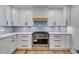 Gourmet kitchen featuring sleek white cabinets, stainless steel appliances, and modern backsplash at 2055 Timberland Dr, Cumming, GA 30040