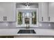 A kitchen sink in front of a window, with modern faucet and gray tile backsplash at 2055 Timberland Dr, Cumming, GA 30040