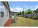 View of the backyard with a well-maintained lawn, privacy fence, and home exterior at 2431 Kingston Heath Way, Marietta, GA 30008
