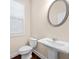 Cozy powder room featuring a pedestal sink, toilet, and window at 2431 Kingston Heath Way, Marietta, GA 30008