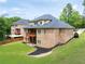 Aerial view of a brick house with multiple decks, a large yard, and manicured landscaping at 3512 Centerville Rosebud Rd, Snellville, GA 30039