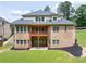Spacious backyard featuring a brick home with a deck, patio, and manicured landscaping at 3512 Centerville Rosebud Rd, Snellville, GA 30039