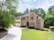 Charming brick home with a well-manicured lawn, driveway, and mature trees at 3512 Centerville Rosebud Rd, Snellville, GA 30039