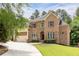 Beautiful brick home featuring manicured landscaping, a three-car garage, and a welcoming front entrance at 3512 Centerville Rosebud Rd, Snellville, GA 30039