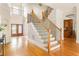 Elegant foyer with hardwood floors, a staircase with iron railings, and a view of the front entrance at 3512 Centerville Rosebud Rd, Snellville, GA 30039