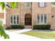 Charming brick home featuring a stone archway, double doors, manicured shrubs and a well-kept lawn at 3512 Centerville Rosebud Rd, Snellville, GA 30039