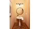 Cozy powder room with a pedestal sink, round mirror, overhead light fixture, and hardwood floors at 3512 Centerville Rosebud Rd, Snellville, GA 30039