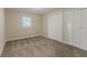 Bedroom with neutral walls, plush carpet, closet with white louvered doors, and a window at 545 Fayetteville Rd, Fairburn, GA 30213