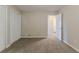 Bedroom with plush carpeting, louvered closet, and open door to a bathroom beyond at 545 Fayetteville Rd, Fairburn, GA 30213