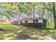 Landscaped home featuring dark brick, bright white siding, and lots of large trees at 545 Fayetteville Rd, Fairburn, GA 30213