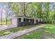 Home with dark brick, attached garage, fresh green lawn, and sidewalk to the front door at 545 Fayetteville Rd, Fairburn, GA 30213