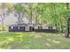 Charming home with a dark brick facade, contrasting white siding, and a lush green lawn at 545 Fayetteville Rd, Fairburn, GA 30213