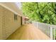 Spacious wooden deck with a railing next to the brick house and green trees at 733 San Fernando Se Dr, Smyrna, GA 30080