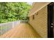 Wide wooden deck with white railing next to the brick house and green trees at 733 San Fernando Se Dr, Smyrna, GA 30080