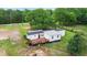 Aerial view of a home with a wooden deck, surrounded by a lush green yard and mature trees at 901 N Van Wert Rd, Villa Rica, GA 30180