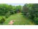 Scenic view of a classic red barn surrounded by a lush green meadow and mature trees at 901 N Van Wert Rd, Villa Rica, GA 30180