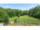 Scenic view of a sprawling property, a red barn, lush greenery, and horse grazing at 901 N Van Wert Rd, Villa Rica, GA 30180