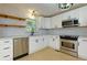Modern kitchen featuring stainless steel appliances, floating shelves, and white cabinets at 2917 Reveille Se Cir, Atlanta, GA 30316