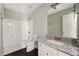 Bright bathroom featuring a tub with white tile surround, granite countertop vanity, and a framed mirror at 3570 Steve Nw Dr, Marietta, GA 30064