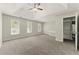 Spacious bedroom with a tray ceiling, three bright windows, neutral carpeting, and an attached doorway at 3570 Steve Nw Dr, Marietta, GA 30064