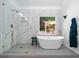 Elegant bathroom with a modern tub, a glass shower and a window with an outdoor view at 3707 Lance Bluff Ln, Duluth, GA 30097