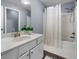 Well-lit bathroom featuring a shower-tub combo, white vanity, and decorative mirror at 3707 Lance Bluff Ln, Duluth, GA 30097
