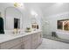 Bright bathroom featuring double sinks with gold hardware, soaking tub and glass enclosed shower at 3707 Lance Bluff Ln, Duluth, GA 30097