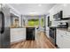 Light eat-in kitchen with a view of greenery, stainless steel appliances, and hardwood floors at 3707 Lance Bluff Ln, Duluth, GA 30097