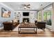 Bright living room with a ceiling fan, built-in shelves, fireplace and large windows at 3707 Lance Bluff Ln, Duluth, GA 30097