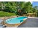 Backyard featuring a gorgeous pool, stone walls, lush landscaping, and an outdoor dining area at 3707 Lance Bluff Ln, Duluth, GA 30097