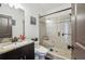 Modern bathroom with a glass-enclosed shower, granite countertops, and dark wood cabinets at 5068 Bentwater Sw Ln, Lilburn, GA 30047