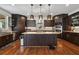 Modern kitchen with dark wood cabinetry, granite countertops, an island, and stainless steel appliances at 5068 Bentwater Sw Ln, Lilburn, GA 30047