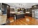 Bright kitchen with stainless steel appliances, central island, granite countertops, and hardwood floors at 5068 Bentwater Sw Ln, Lilburn, GA 30047