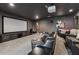 Home theater room with black leather recliner seating, movie screen, and projector at 5068 Bentwater Sw Ln, Lilburn, GA 30047