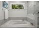 Bathroom featuring a soaking tub with decorative black-and-white mosaic tile at 770 Ormewood Se Ave, Atlanta, GA 30312