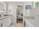 Bright bathroom featuring a double vanity and a soaking tub with views into a bedroom at 770 Ormewood Se Ave, Atlanta, GA 30312