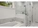 Bright bathroom showcasing a soaking tub and glass-enclosed shower with decorative tile at 770 Ormewood Se Ave, Atlanta, GA 30312