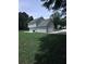 A grassy lawn with a partial view of a two-story home with light blue siding and an attached garage at 1201 Saint Andrews Dr, Auburn, GA 30011