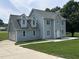 Charming two-story home with light blue siding, gray roof, attached garage and expansive green lawn at 1201 Saint Andrews Dr, Auburn, GA 30011