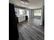 Bright eat-in kitchen with black appliances, white cabinets and gray wood-look flooring at 1201 Saint Andrews Dr, Auburn, GA 30011