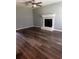 Spacious living room with dark hardwood floors, fireplace, ceiling fan, and neutral gray walls at 1201 Saint Andrews Dr, Auburn, GA 30011