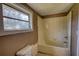 Bathroom featuring a tub/shower combination and a window for natural light at 2228 Emory St, Covington, GA 30014